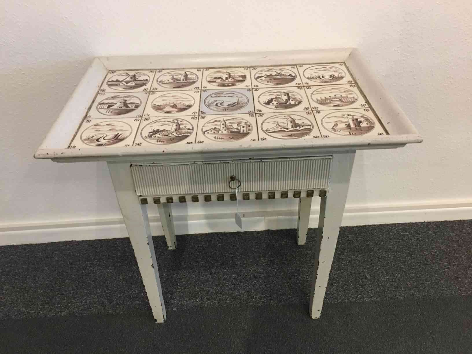 Hvidt tobaksbord fra 1700 tallet i Luis Seiz stil, med kakler i brunlige farver. Højde 71, bredde 75, dybde 49 cm i flot stand. Pris: 7.500,- Kr.