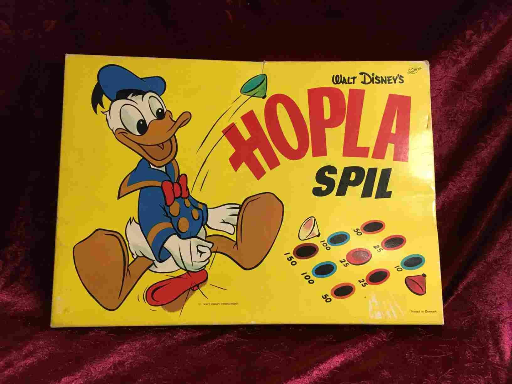 Hopla - Originalt Disney spil der er sjovt for både børn og voksne, det gælder om at få en top til at hoppe i hul, hvor den giver flest point. Let at lære, selv for yngre børn. Flot original stand. Solgt