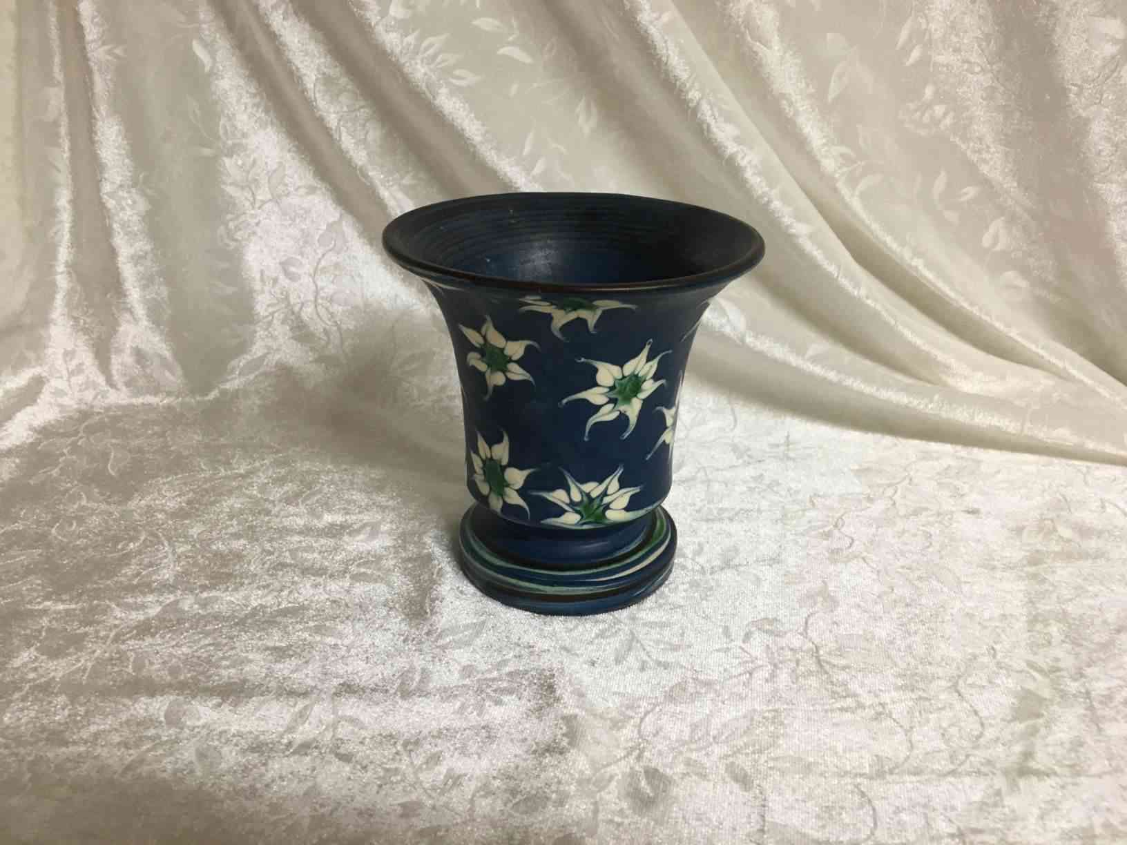 Kähler vase 11 cm blå bundfarve med lyse blomster. Vasen er horndekoreret med mat glasur ca. 1920 af Tulle Emborg. Pris: 575,- Kr.