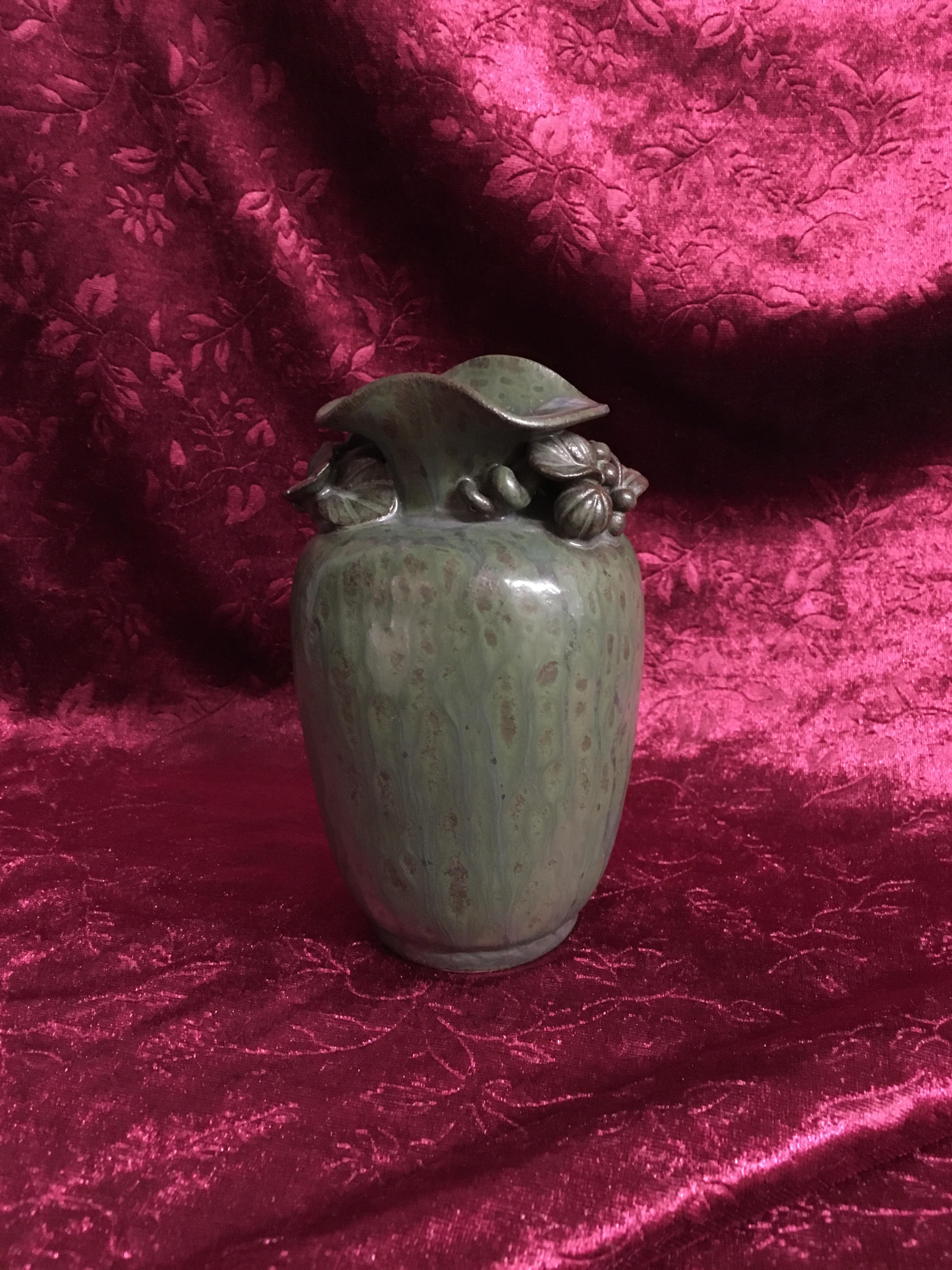 Arne Bang Vase med opmodelerede blomster, grønglaseret stentøj, signeret AB samt nr. 16, fremstår med et minimalt glasurafslag, 15 cm høj. Pris: 7.000,- Kr.