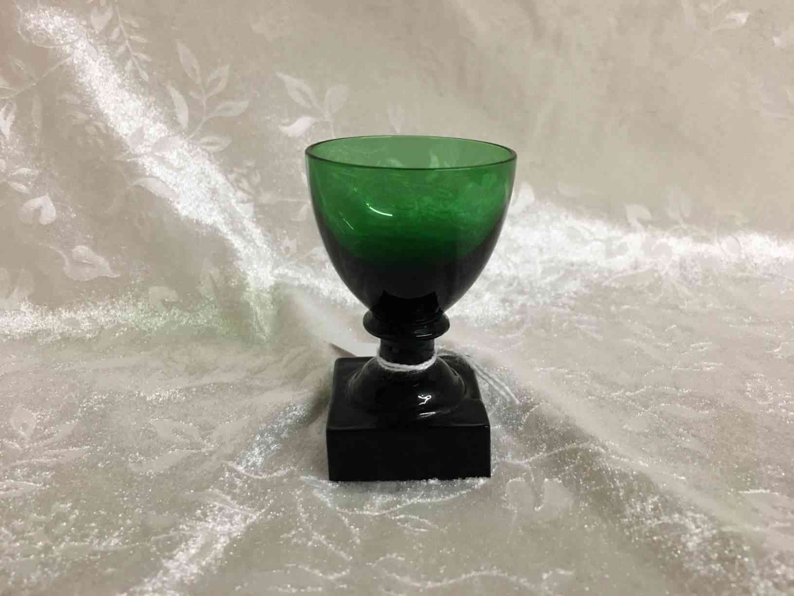 Holmegaard - Gorm den Gamle eller Viking grønt Snaps glas 7 cm i perfekt stand. Pris: 250,- Kr. Glas fremstillet i mørkegrønt glas med kraftig firkantet fod, slebet firkantet eller presset i form, anhæftet mundblæst kumme. Bunden har opstukket "blomst" med runde kronblade. Formen "Skålform" er fra 1900, senere i 1920 udførtes de i mørkegrønt glas blandt andet til glasgrosserer Wiggo Dahl der solgte dem som "Gorm den Gamle". Holmegaard overtog senere forhandlingen af glassene og solgte dem som "Viking". Kastrup har en lignende serie kaldet Emma, dette er dog med slibninger i kummen.