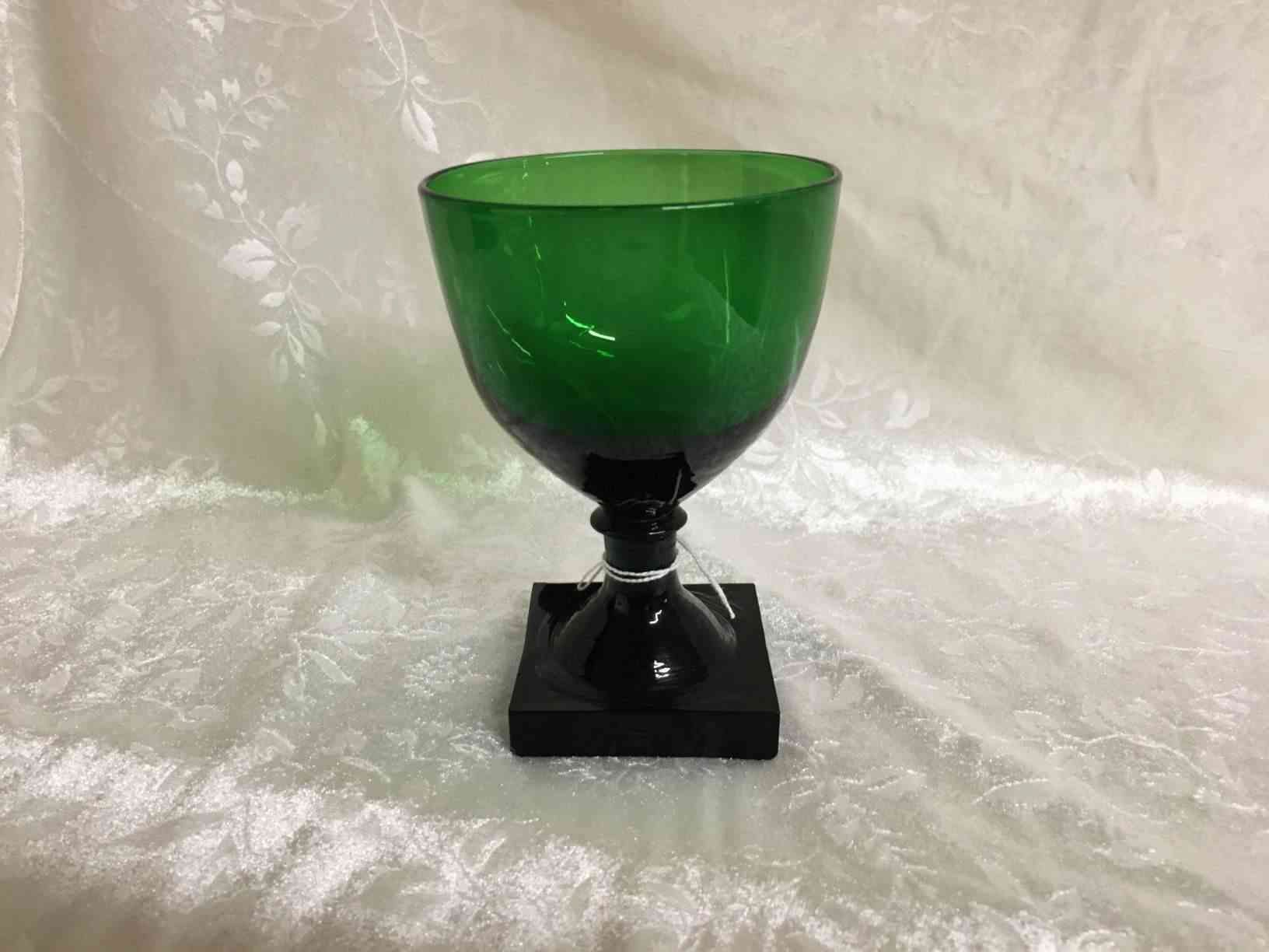 Holmegaard - Gorm den Gamle eller Viking  grønt ølglas 13 cm i perfekt stand. Pris: 750,- Kr. Glas fremstillet i mørkegrønt glas med kraftig firkantet fod, slebet firkantet eller presset i form, anhæftet mundblæst kumme. Bunden har opstukket "blomst" med runde kronblade. Formen "Skålform" er fra 1900, senere i 1920 udførtes de i mørkegrønt glas blandt andet til glasgrosserer Wiggo Dahl der solgte dem som "Gorm den Gamle". Holmegaard overtog senere forhandlingen af glassene og solgte dem som "Viking". Kastrup har en lignende serie kaldet Emma, dette er dog med slibninger i kummen.