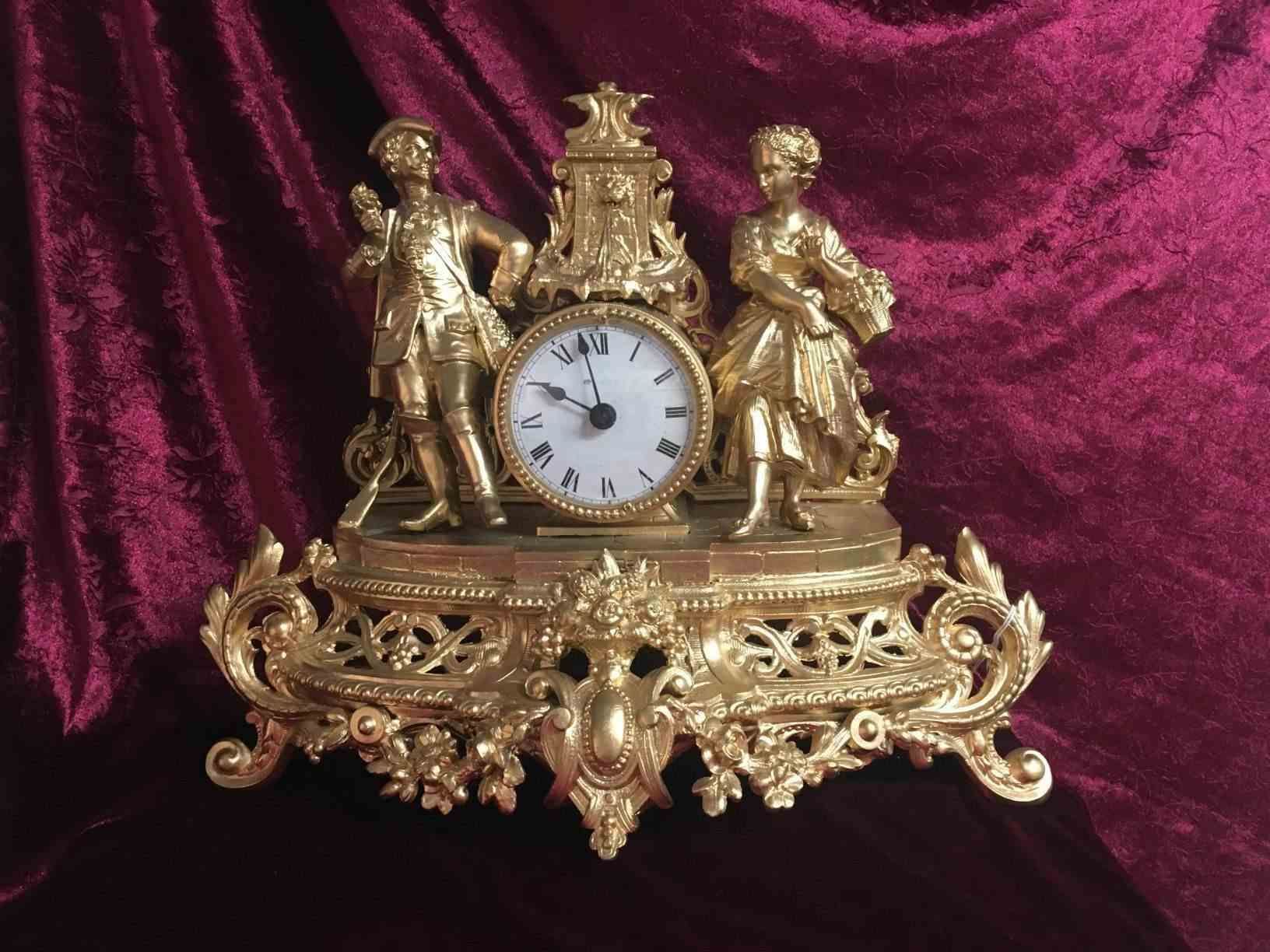 Fransk guldbelagt konsolur med batteridrevet urværk dekoreret med figurer klædt som i 1700 tallet Pris: 975,- Kr.