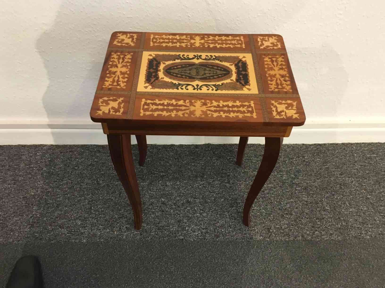Sybord med intarsia og spilledåse Italiensk fra start 1900 tallet. En typisk souvenir for de få der rejste på den tid, mest håndværkere der var på valsen for at dygtiggøre sig. Meget flot stand. Pris 475,- Kr.