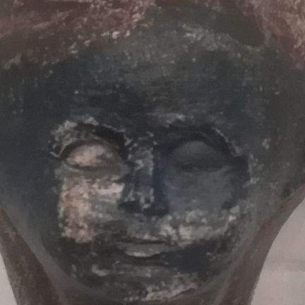 Close up on flower pot in cobalt and manganese. Face with closed eyes.