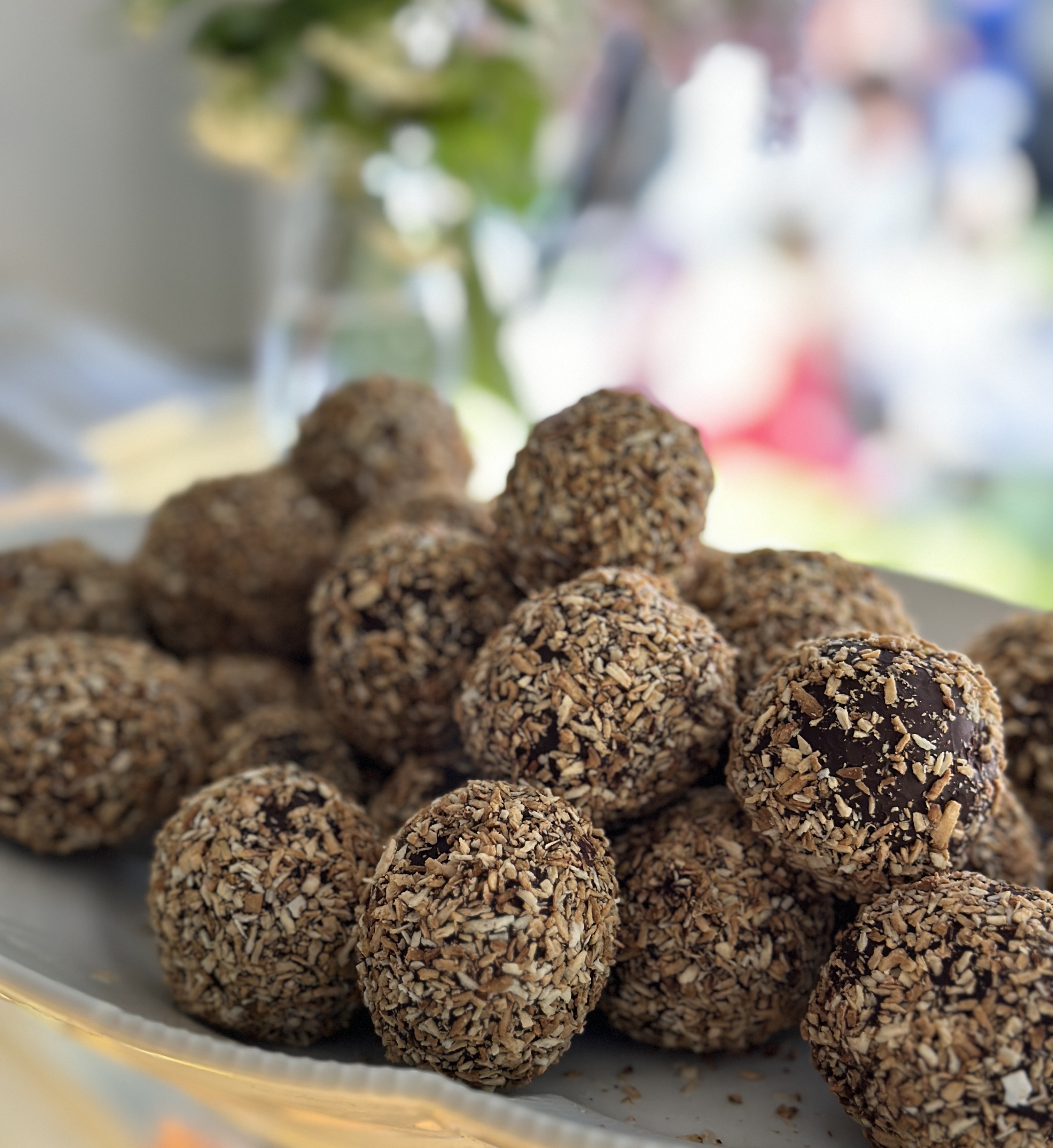 Hjemmebagte romkugler m. rom overtrukket med chokolade og rullet i ristede kokos.