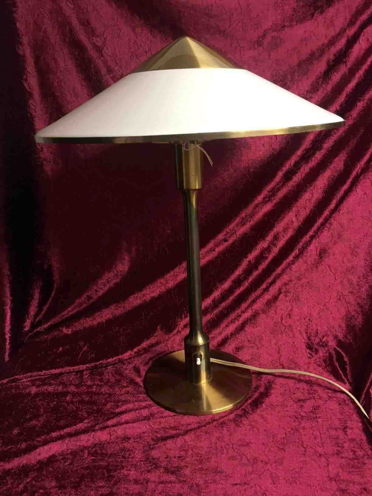 Bordlampe “Kongelyset”. Designet af Niels Rasmussen Thykier i 1930. I 1937 blev produktionen overtaget af Fog Og Mørup og omdøbt kongelys i anledning af Hans Majestæt Kong Christian d. X’s regeringsjubilæum, og på jubilæumsdagen blev et eksemplar overdraget til kongen. Udført i bruneret messing med skærm af plast. Denne er fra 1940'erne i perfekt patineret stand. Pris: 5.800,- Kr.