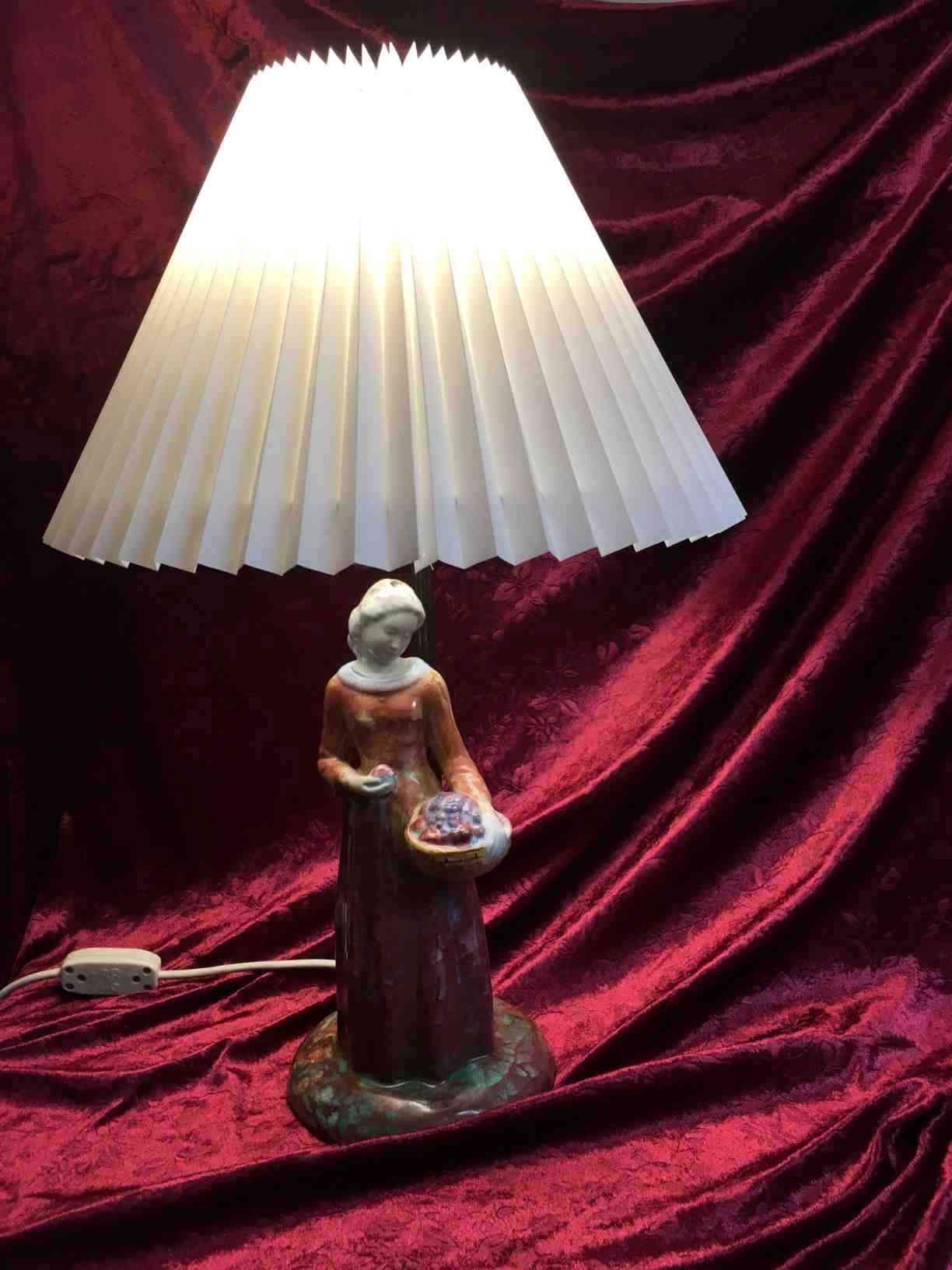 Michael Andersen Bordlampe, prydet med kvinde, keramik, med Persiaglasur, lampestamme af bruneret messing, plisseret skærm, totalhøjde 53 cm. I perfekt stand. Solgt