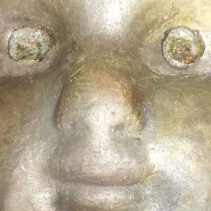 Close up på øjne, næse og mund af gyldent keramisk værk, lavet efter dukkehoved